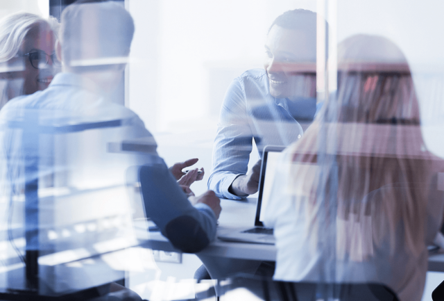 A group of office workers sit around a table generating ideas